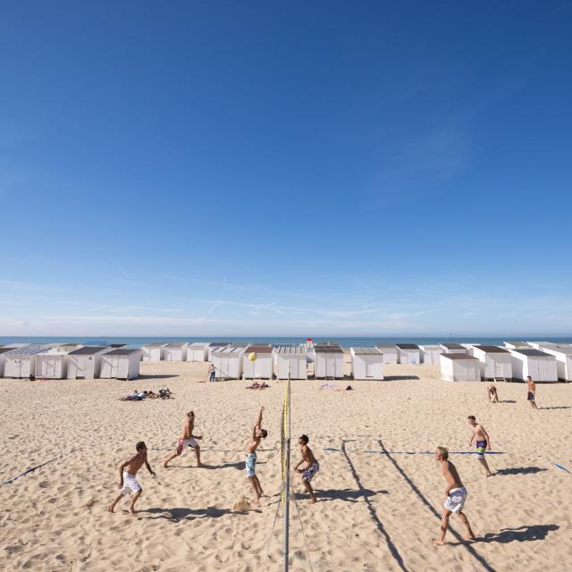 Calais. La plage de Calais avec ses cabines de plage, son port et des joueurs de beach-volley